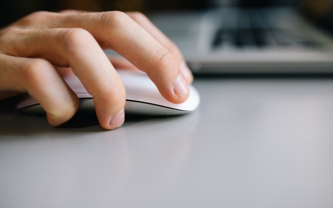 hand moving mouse on a desktop